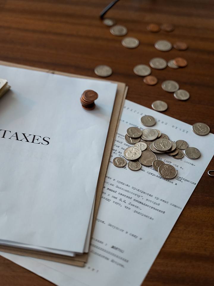 Tax paperwork and coins on a desk