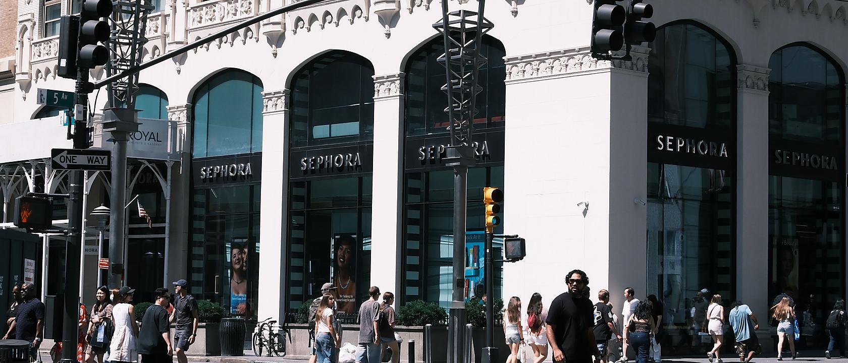 Pedestrians crossing a busy retail street